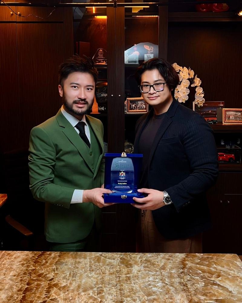 Adha Gozali with Rudy Salim, holding a CEO MasterClass appreciation plaque.