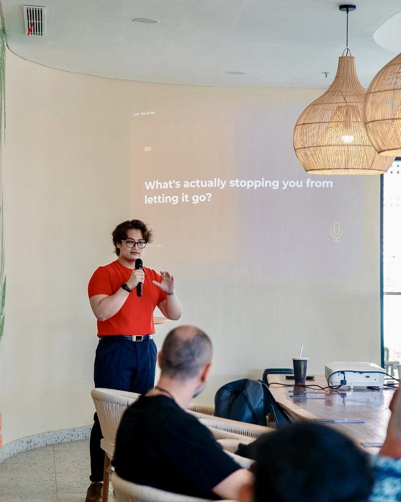 Adha Gozali speaking at a Dayaly Ops founder session, a slide behind him asking what is stopping founders from letting go.