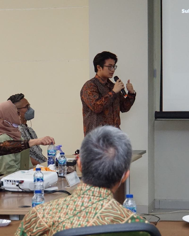 Adha Gozali presenting a business expansion plan for dental distribution to a seated board.